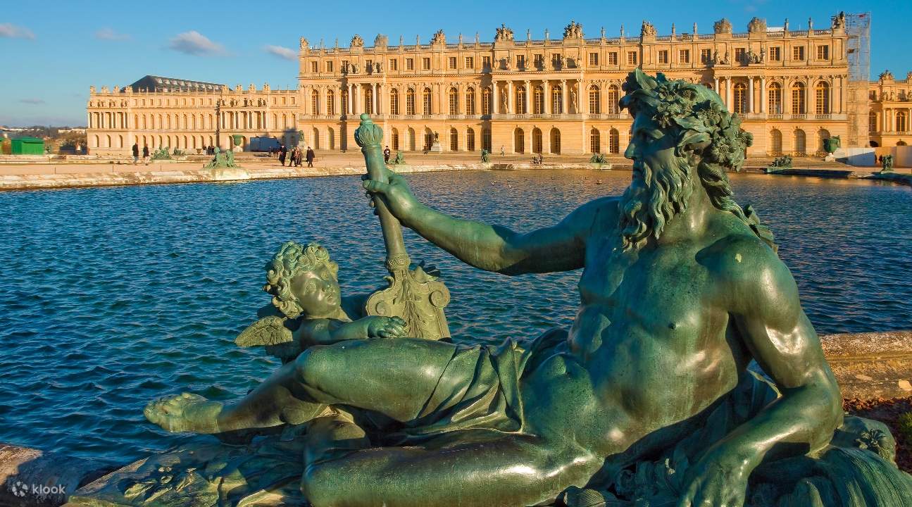 a view of Versailles from a river; a statue is blocking a small section of the castle