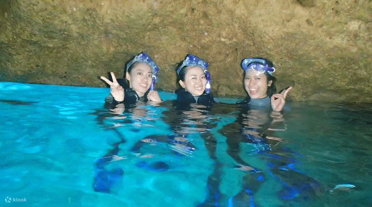 漂浮在冲绳蓝色洞穴内的三个女人