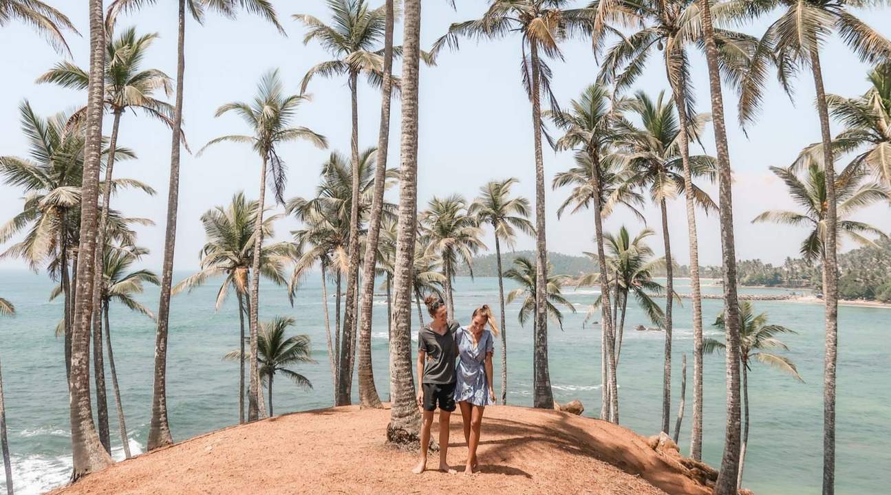man and woman standing in coconut tree hill