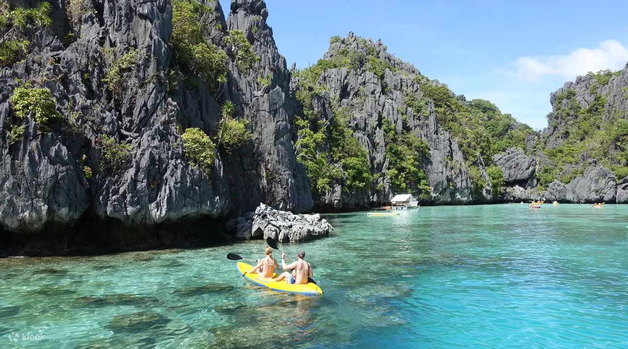 yellow kayak on the ocean with karst formations in the background