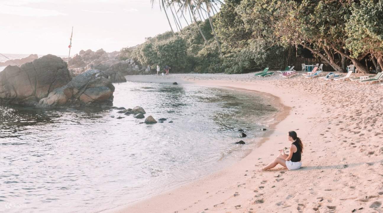 woman sitting on sands in mirissa beach sri lanka