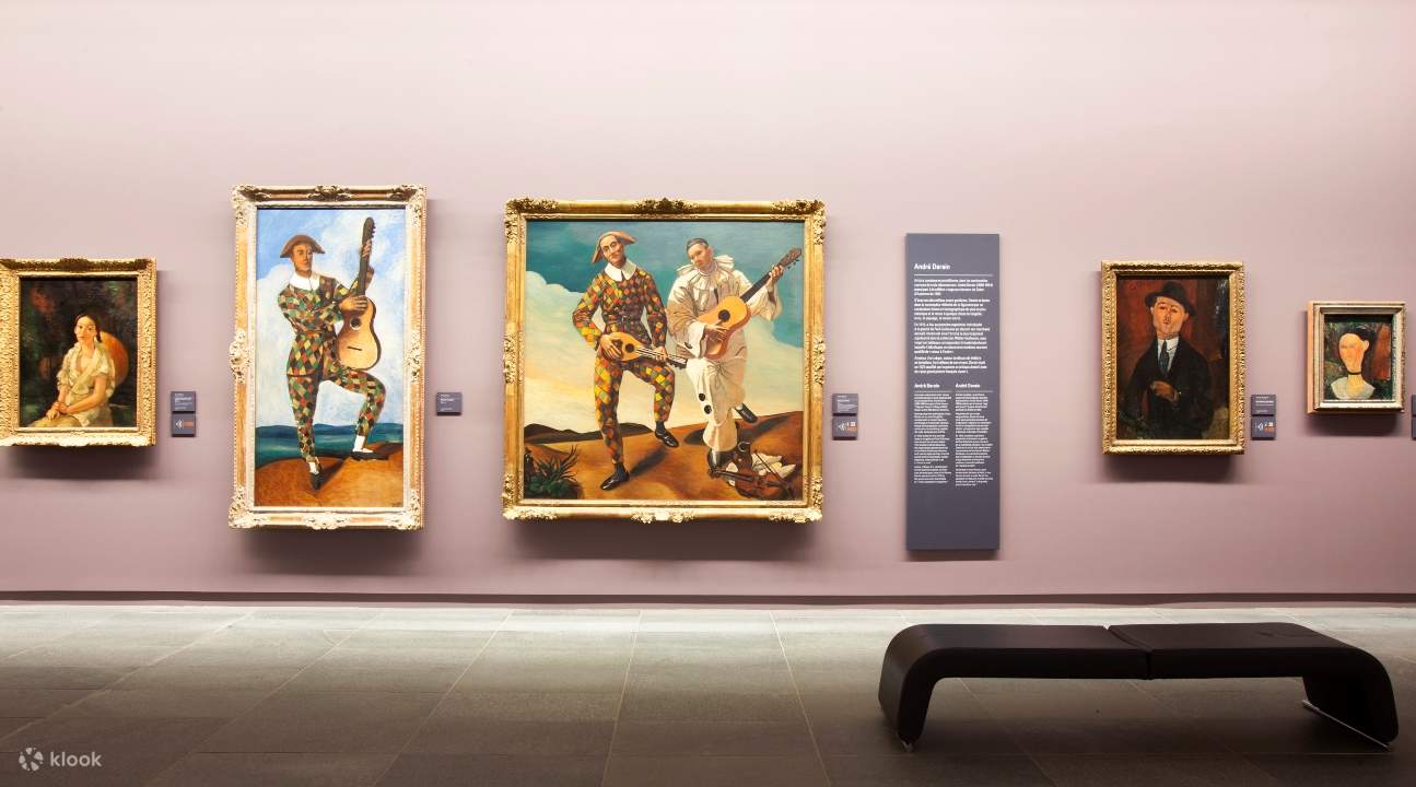 một hành lang đầy những bức tranh được xếp thẳng hàng; có một chiếc ghế dài ở phía dưới bên phải