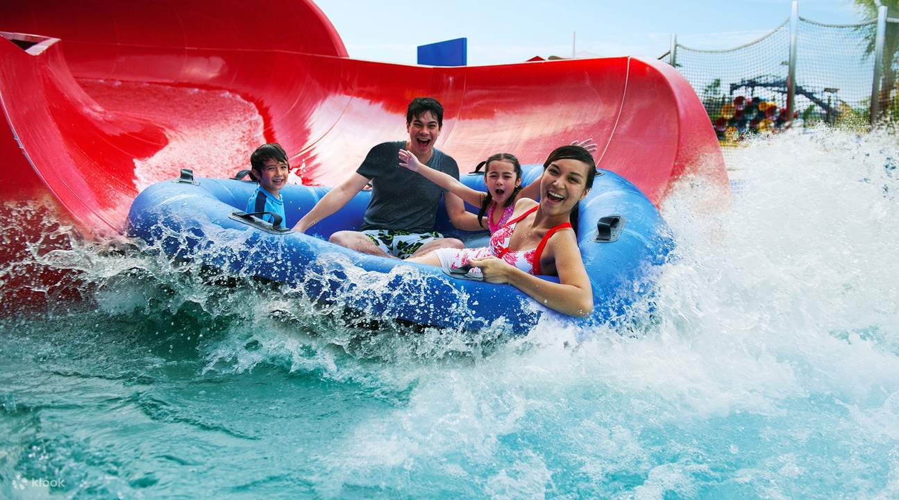 family sliding into the water on a raft