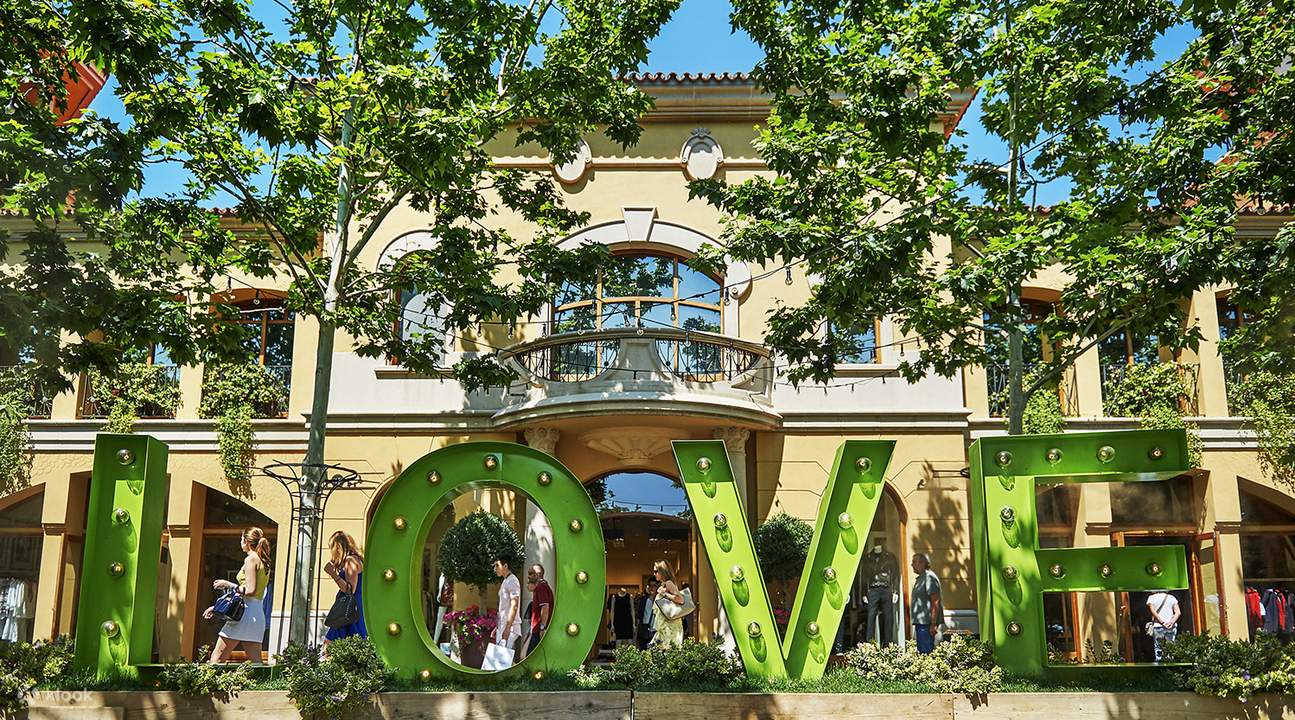 green letters that spell love in front of a building in madrid