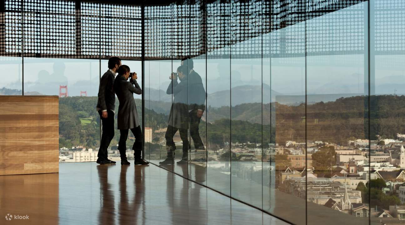 couple taking pictures from the top of de young museum