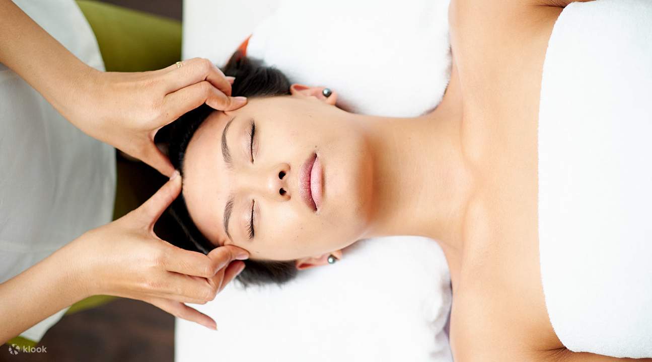 femme allongée recevant un massage du visage