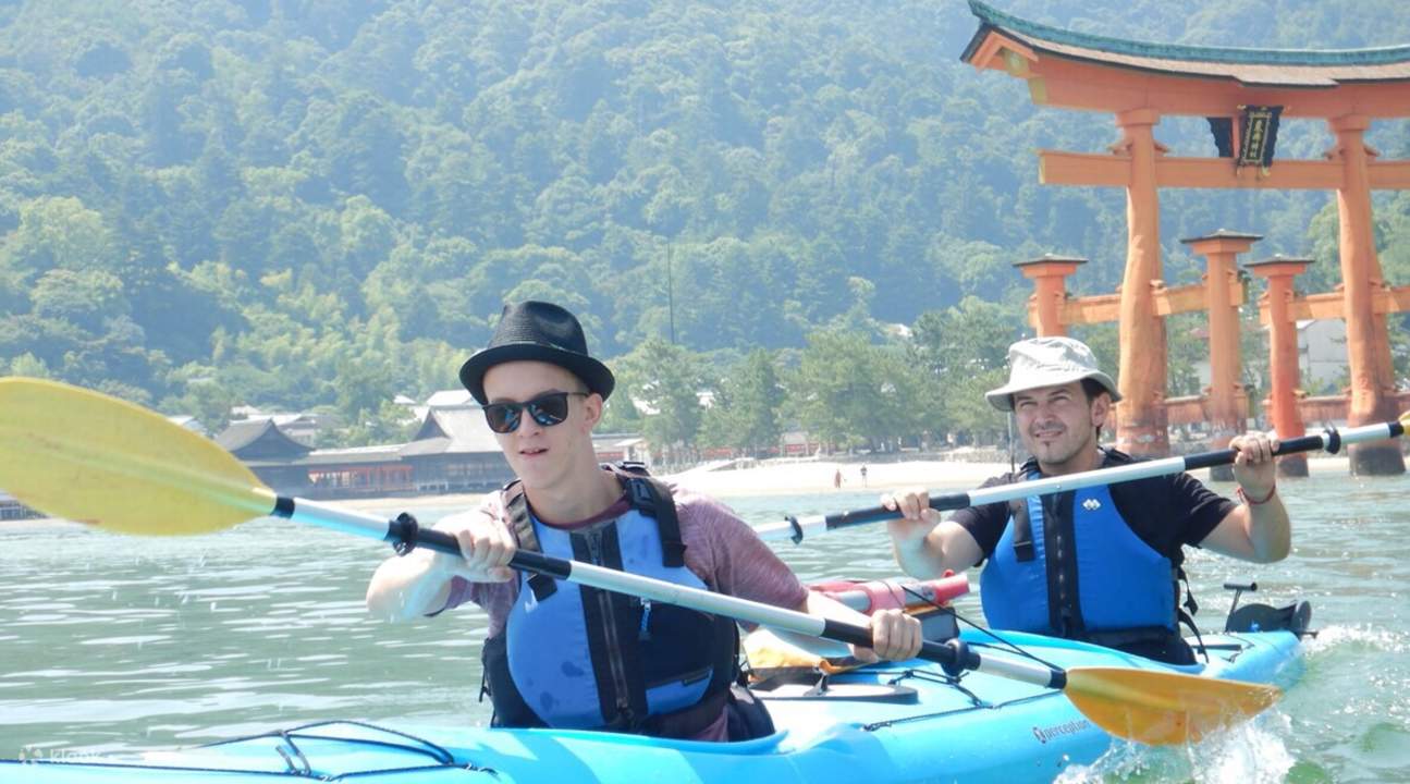 dos hombres en kayak en hiroshima cerca del santuario de itsukushima