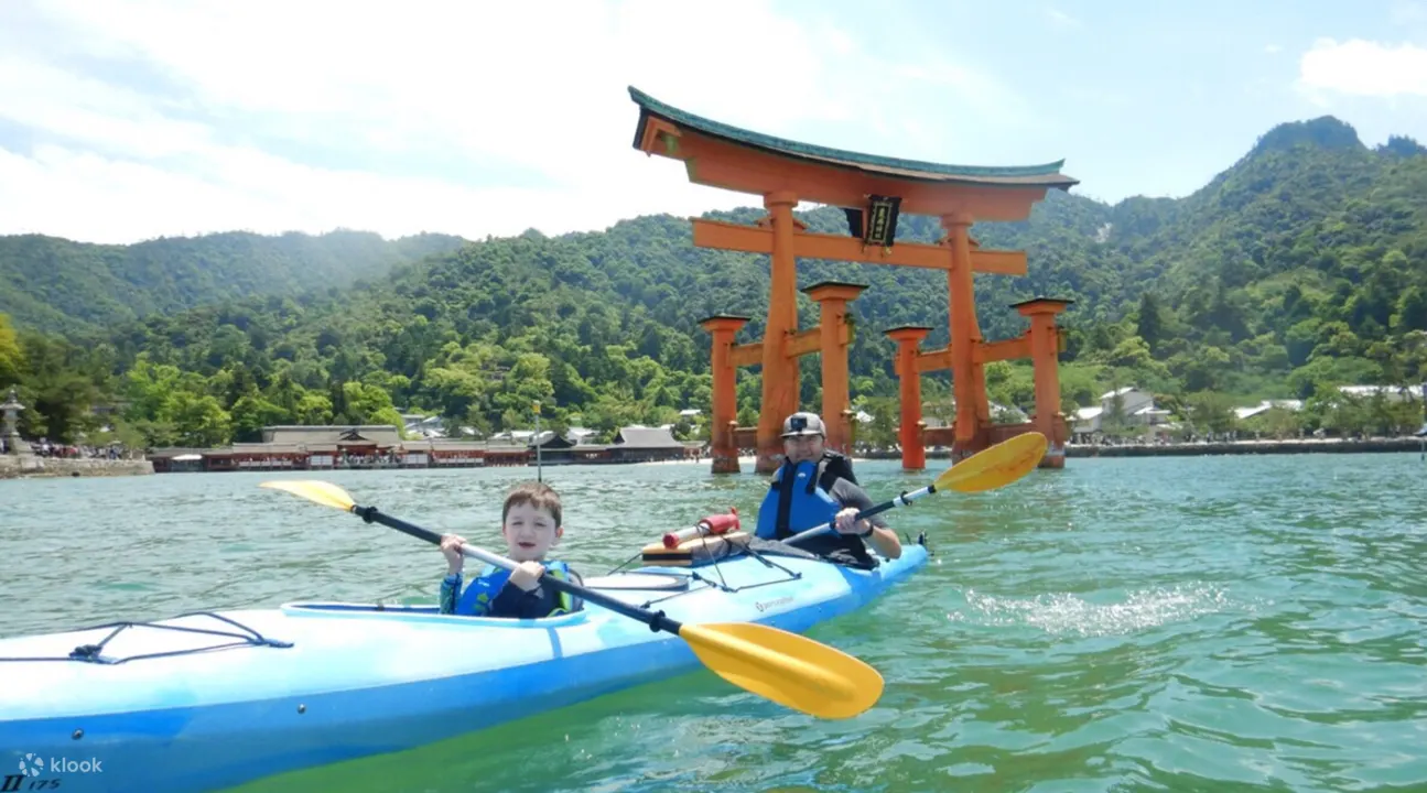 男人和儿子在广岛严岛神社附近划皮划艇