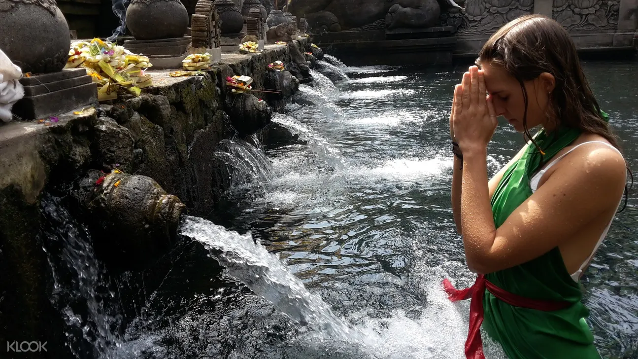 woman praying while at the holy bath in bali