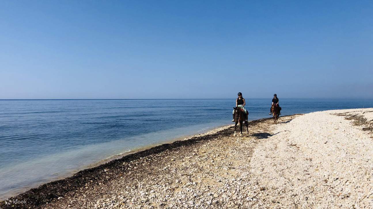Riding along a quiet pebbled shore with endless blue on the horizon
