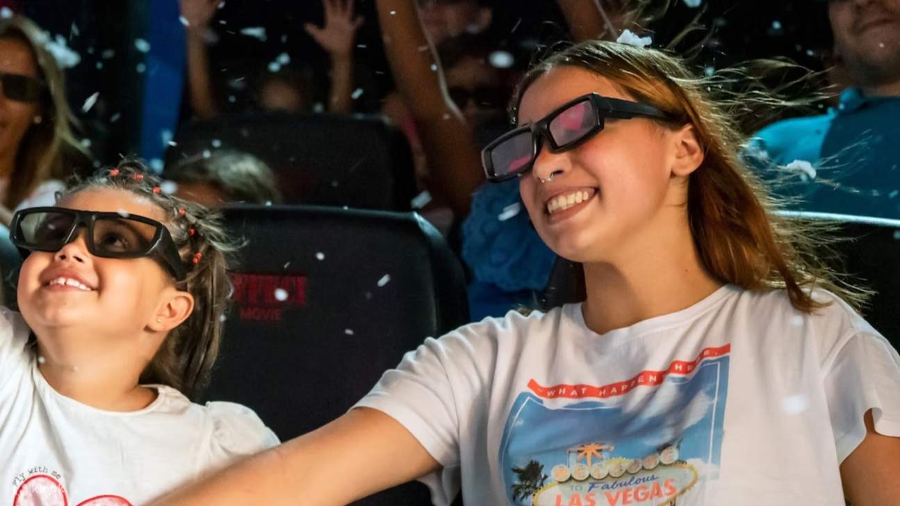 Total begeistert von der Show mit einem Lächeln und großen Augen, während sich das 4D-Abenteuer entfaltet.