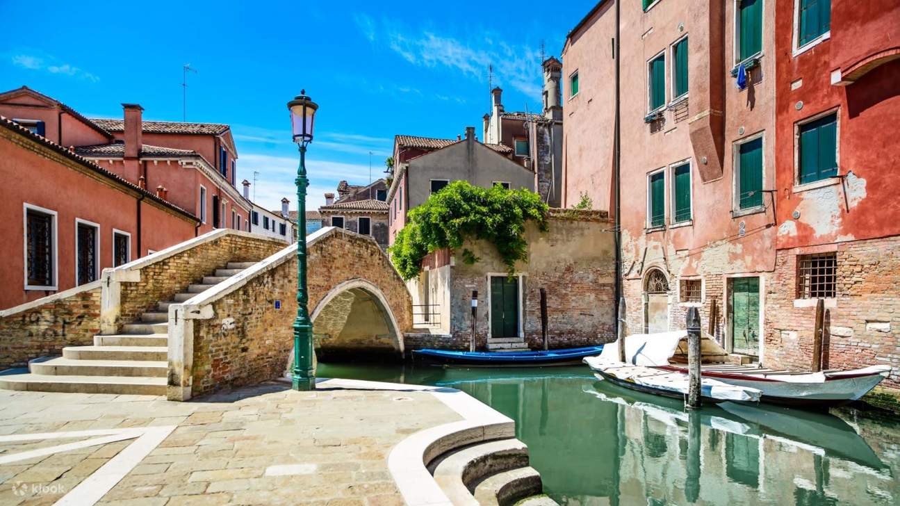 迷人的威尼斯运河，两旁是柔和色调的房屋、古朴的桥梁和宁静的船只
