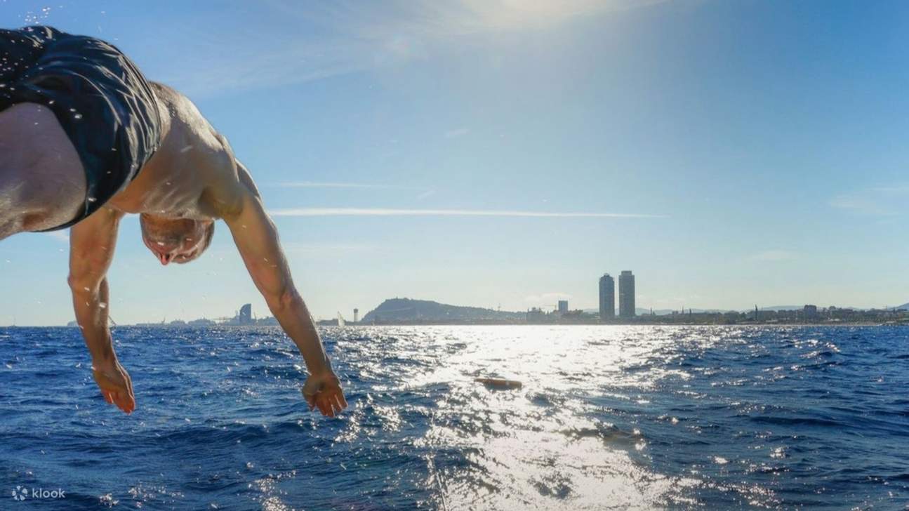 Hombre captado en el aire, saltando desde la cubierta hacia un océano cristalino con gran entusiasmo