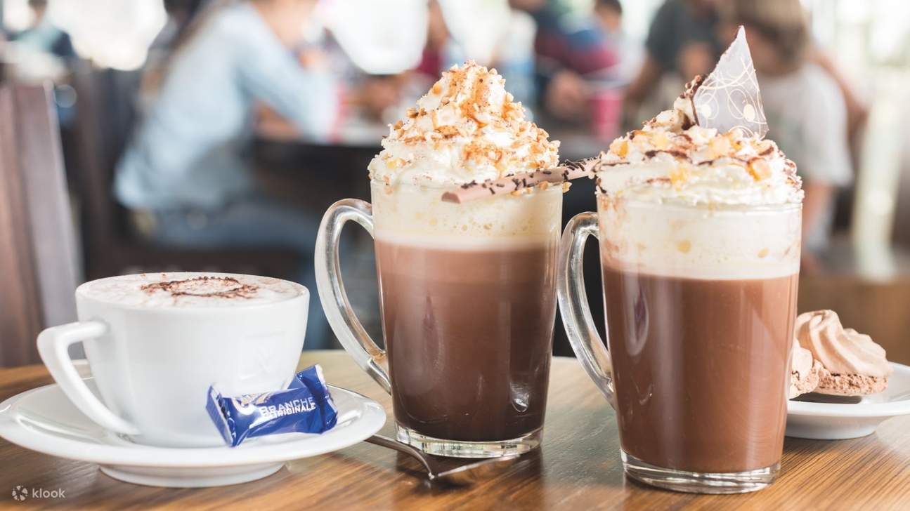 Nikmati minuman coklat panas dan sejuk yang terkenal, pencuci mulut dan makanan ringan di Cafe Cailler