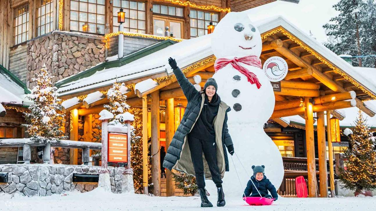 A heartwarming moment captured as mother and daughter pose in front of a giant snowman