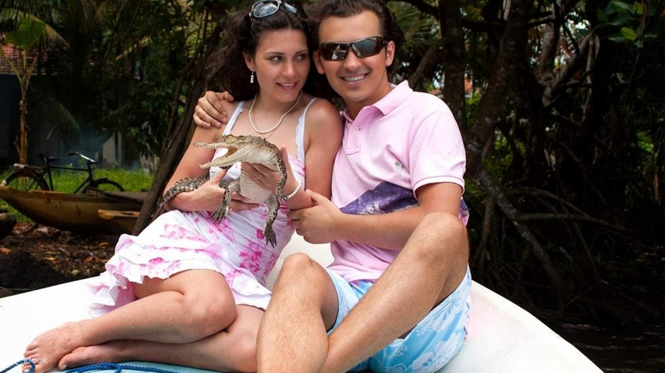 couple tenant un animal dans un safari sur la rivière mangrove bentota