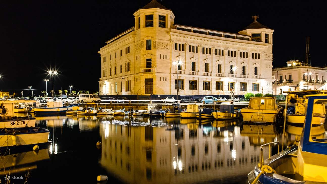 夜晚，优雅的宫殿酒店散发着温暖的光芒，在平静的水面上映出美丽的倒影
