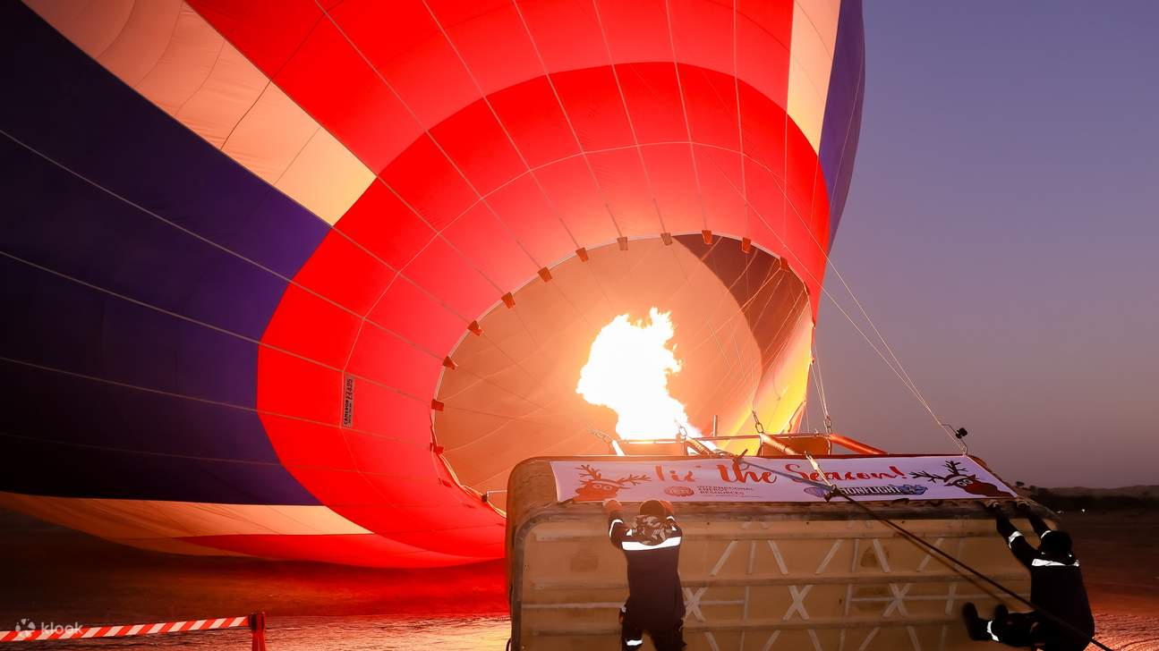 Balon udara panas mengembang dengan semburan api, bersiap untuk pendakian matahari terbit yang mempesona