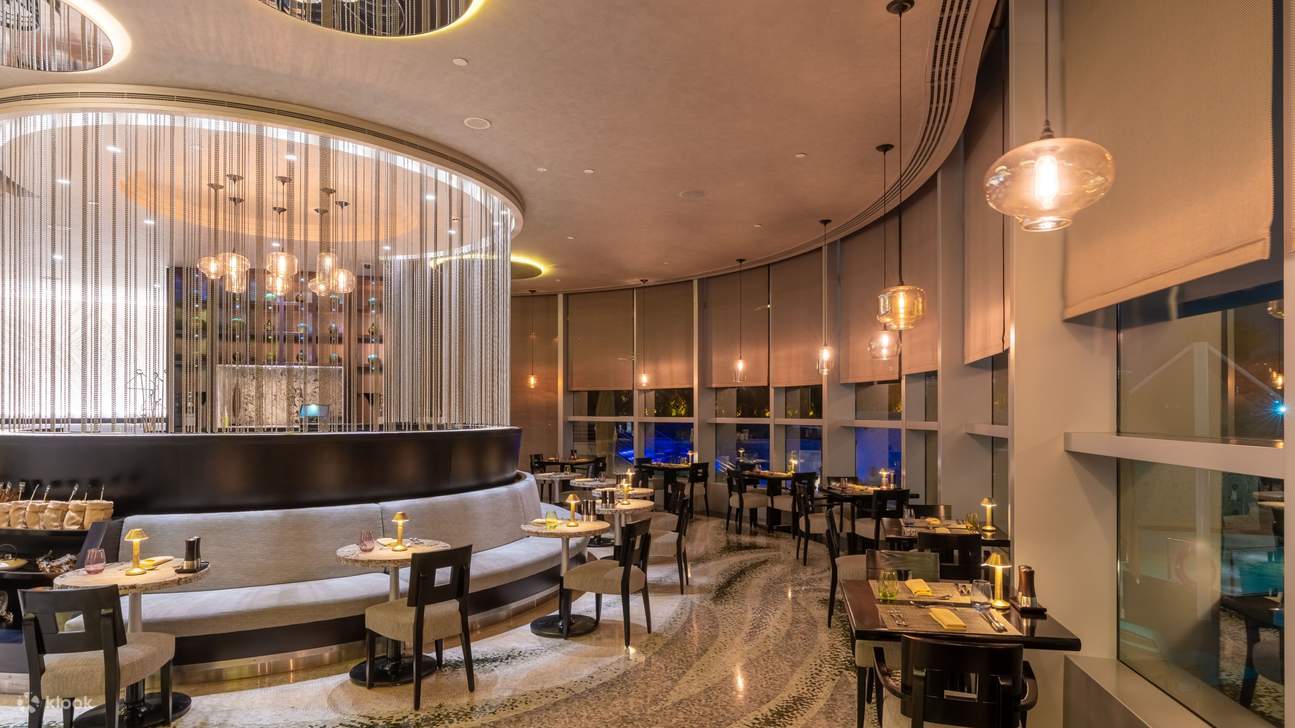 Interior restoran bergaya yang menampilkan pencahayaan elegan, tempat duduk mewah, dan dekorasi modern