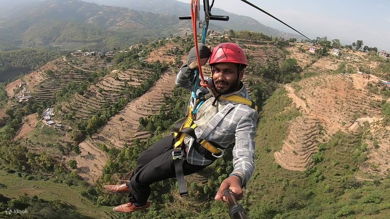 uomo sulla zipline con vista sulle terrazze di riso a Dhulikhel