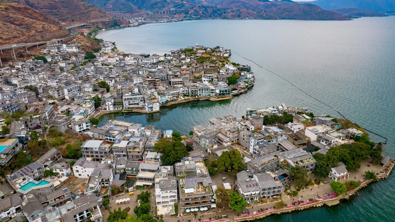 因为临海，又面向南诏风情岛，双廊小镇地理位置得天独厚，风景美到极致。天蓝云白，湖水波澜不惊，水面一艘乌篷小舟，岸边红花点缀