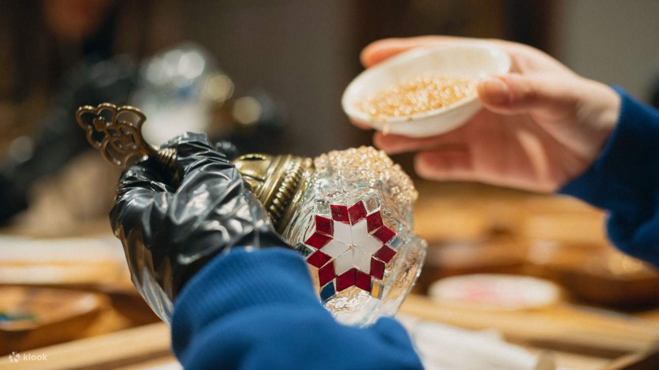 Applicare tessere di mosaico su un motivo floreale durante un laboratorio di lampade turche a Istanbul