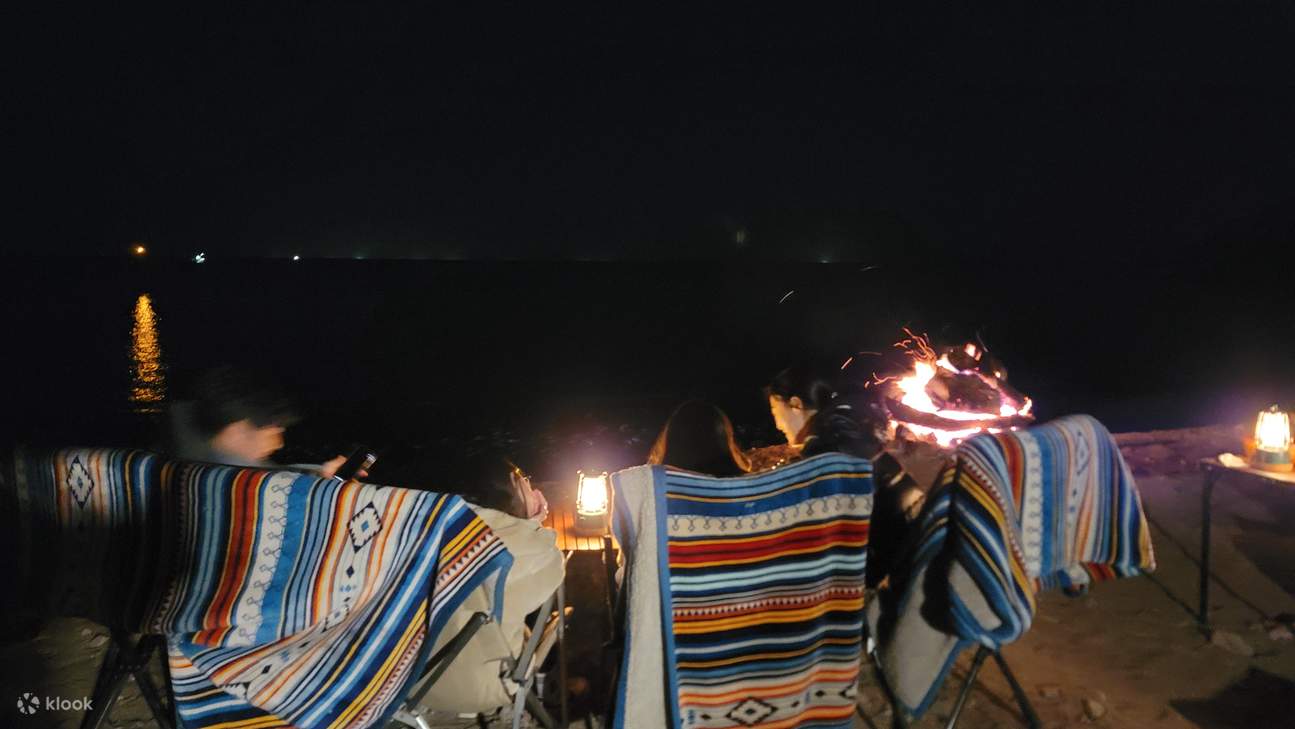 Группа гостей сидит вокруг и разбивает лагерь.