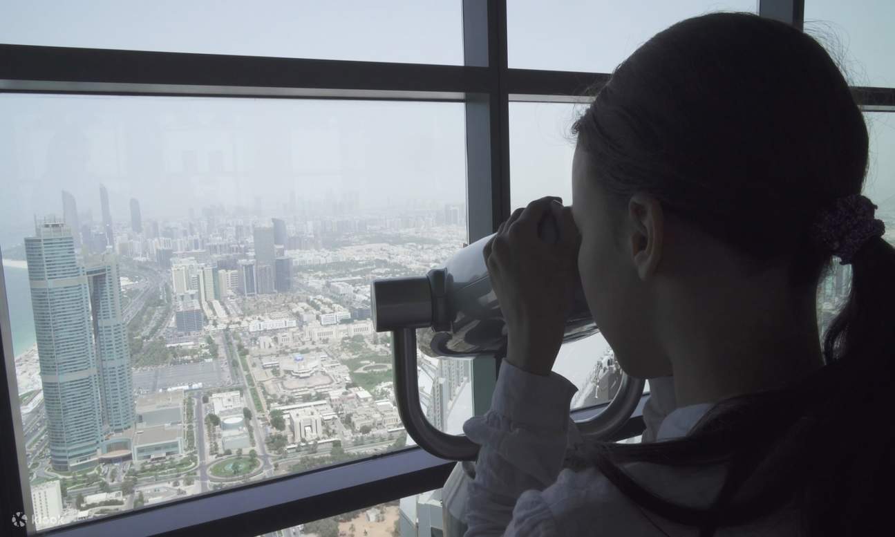 Ragazza che usa un telescopio nella piattaforma di osservazione delle torri Etihad