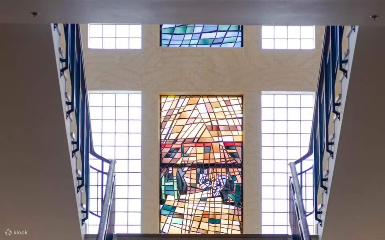 Bewundern Sie die Buntglasfenster, die ein lebendiges, natürliches Licht durch das gesamte Treppenhaus des Museums werfen.