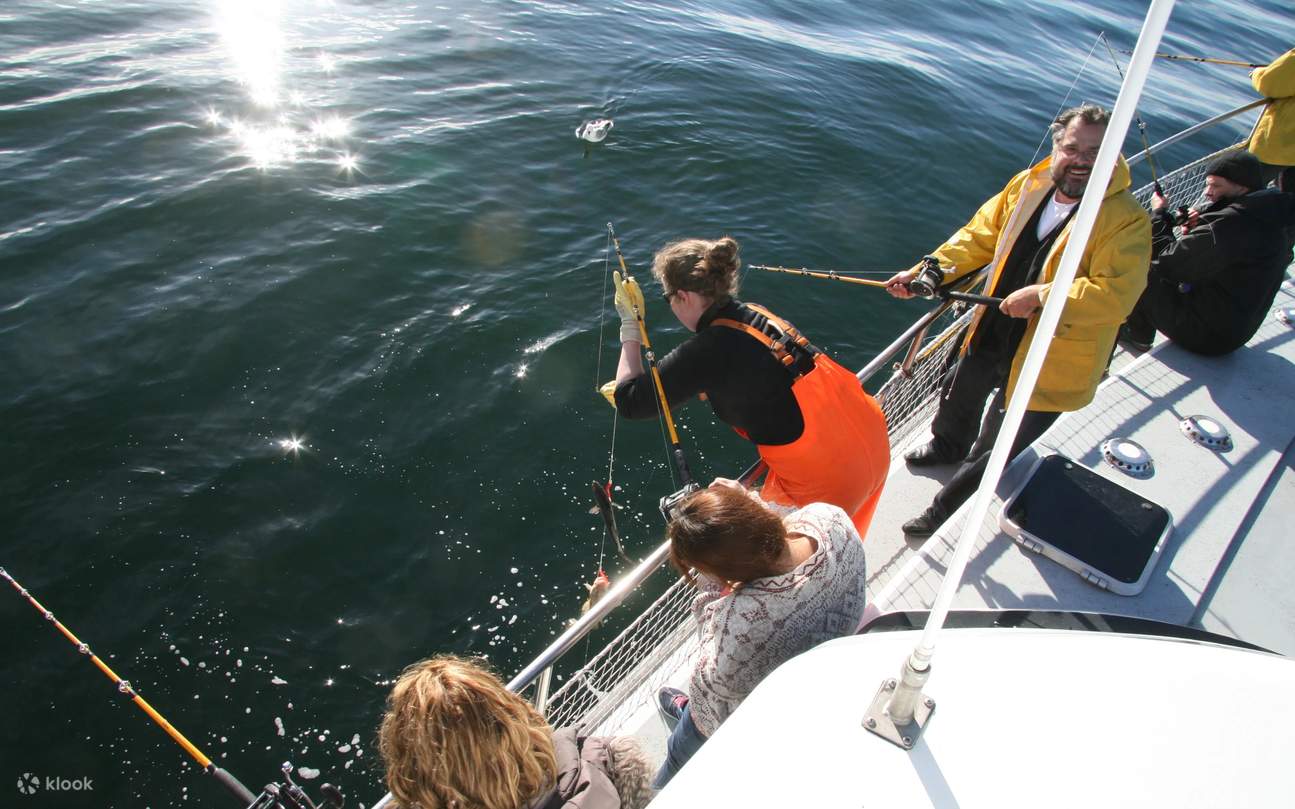 A guest steadily turns the reel, pulling a taut line from deep water