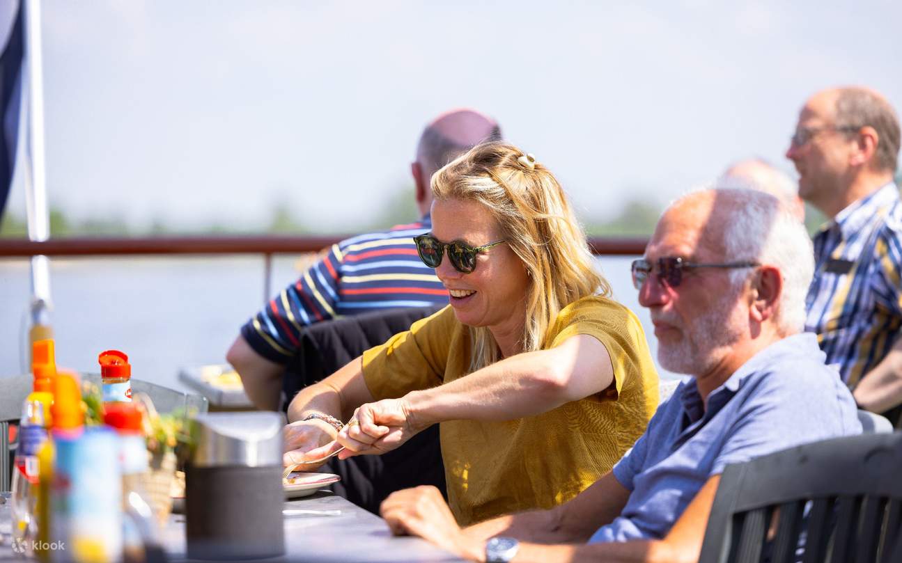 ゲストが美味しいパンケーキと川の景色を楽しみながら、賑やかな会話と笑い声が響き渡ります