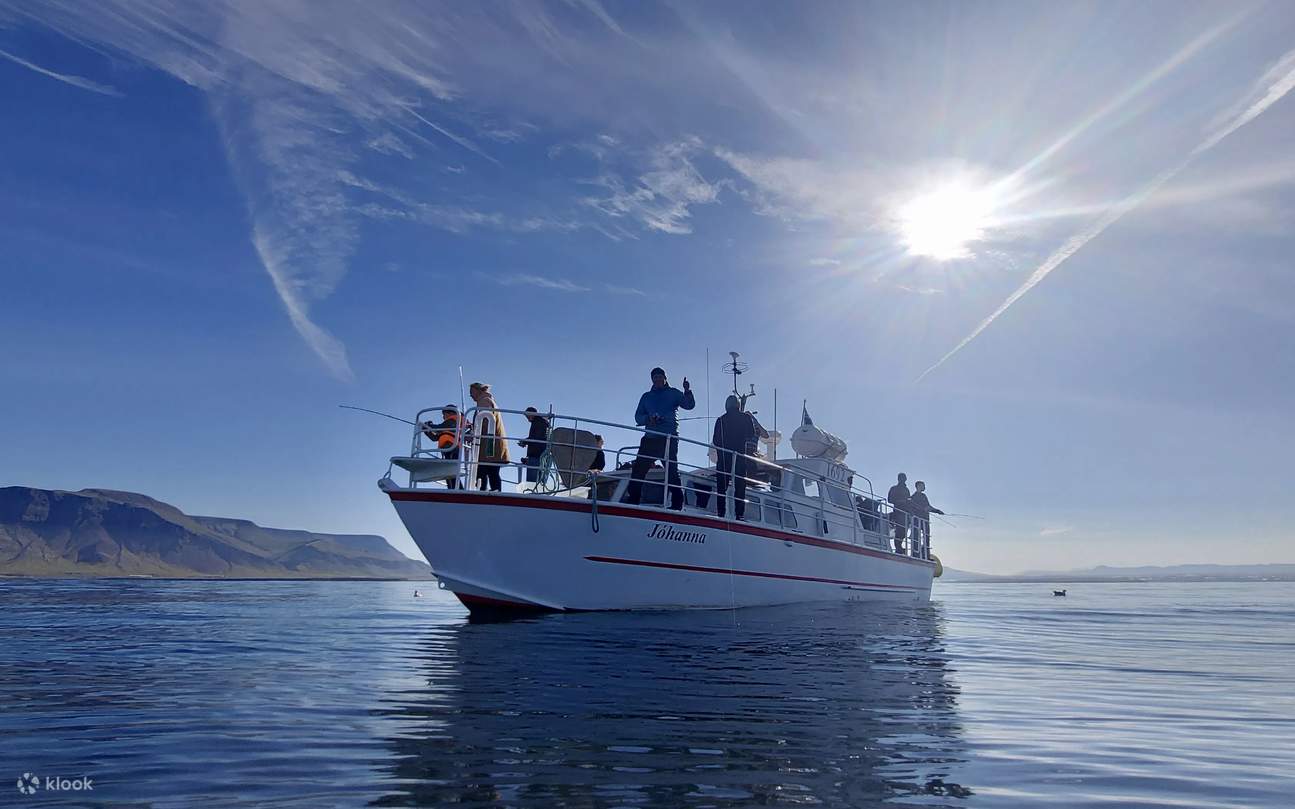 The fishing boat floats peacefully as guests lower lines into the open sea
