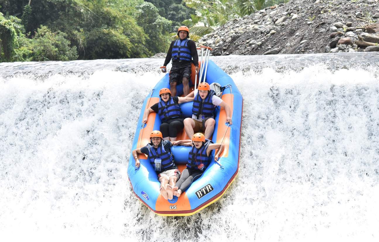 Group on raft sliding down waterfall