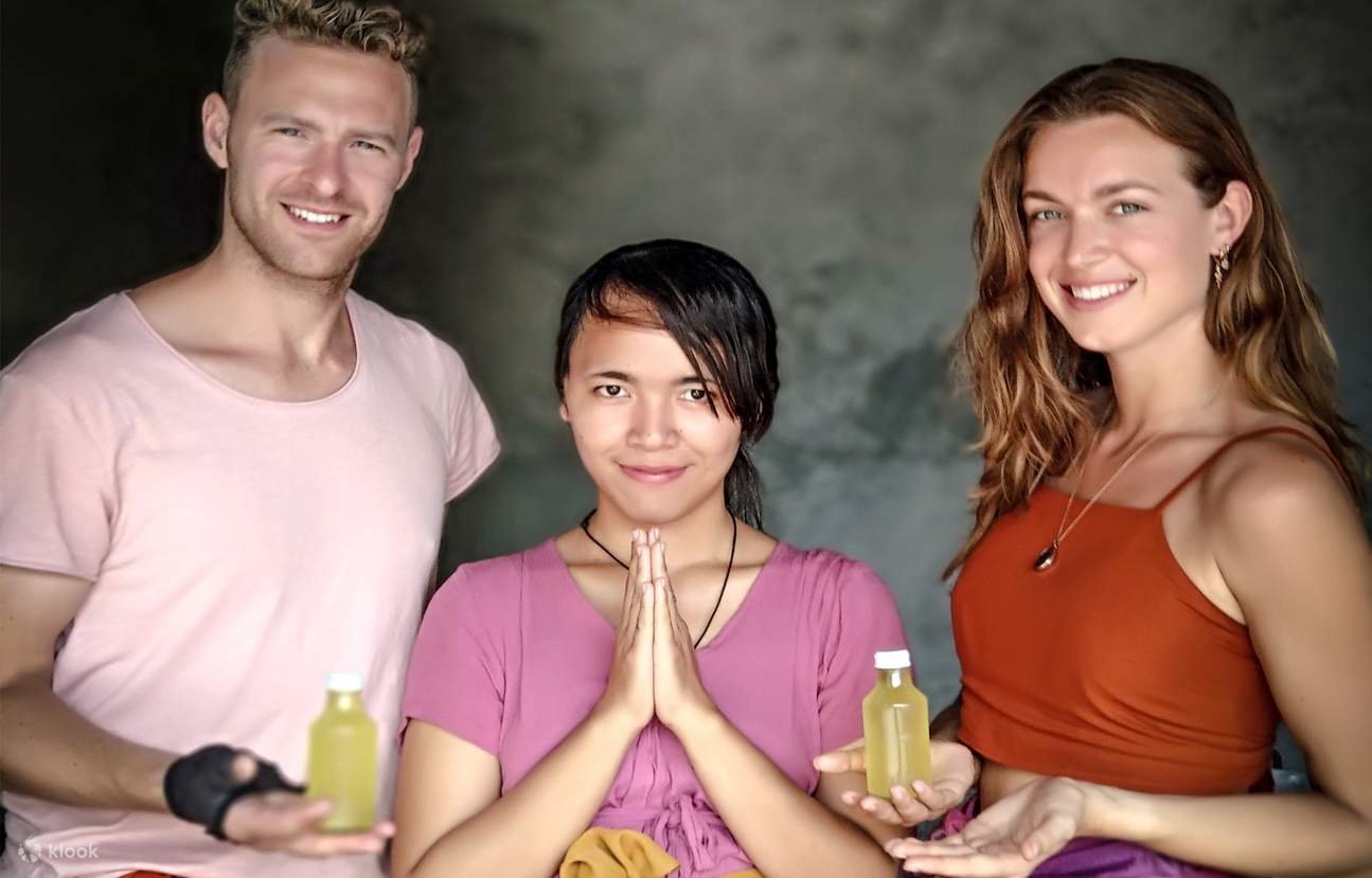 participantes sosteniendo sus aceites de coco embotellados para llevarlos a casa