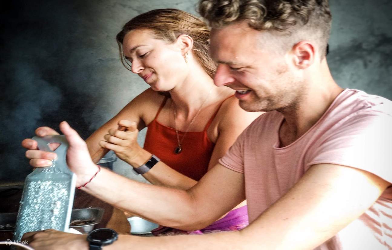 Mujer cortando la cáscara de coco por la mitad.