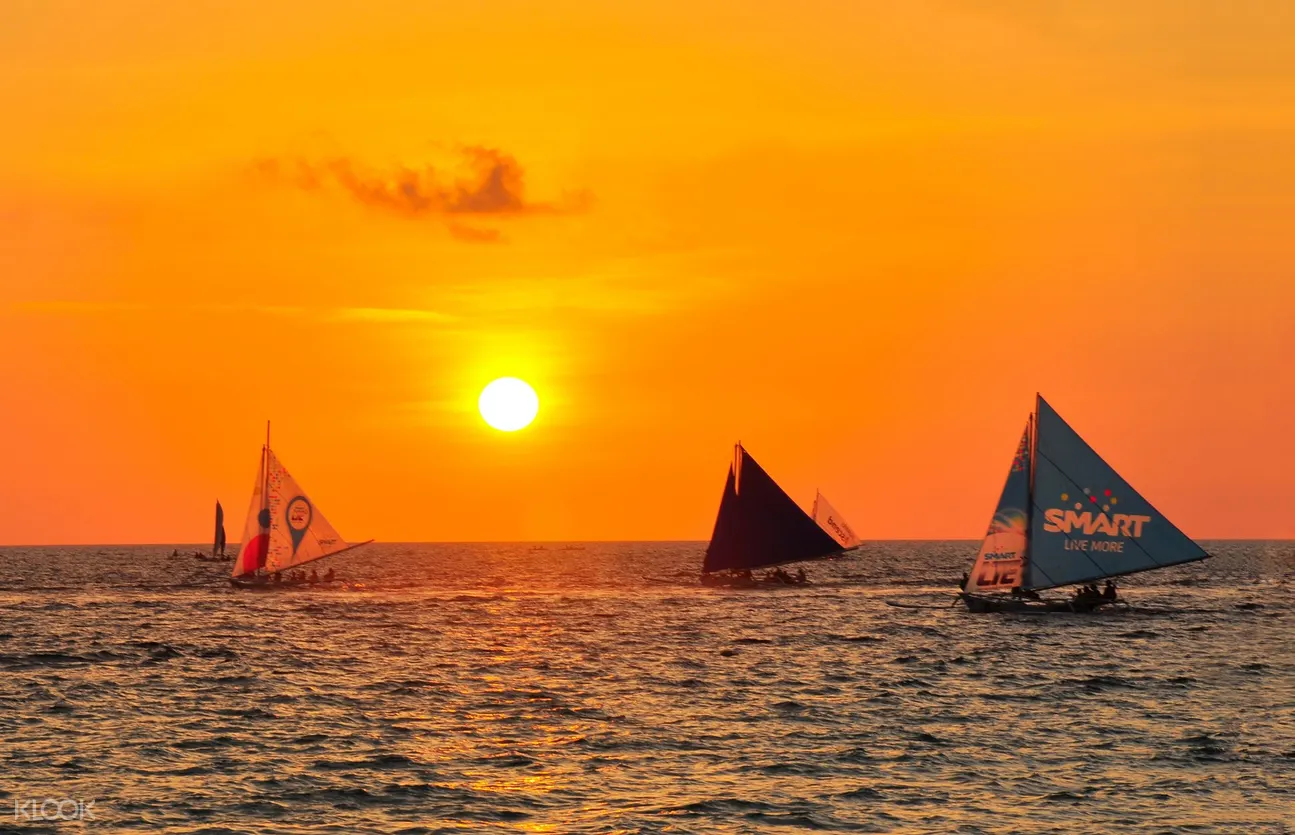 sunset in boracay with sail boats