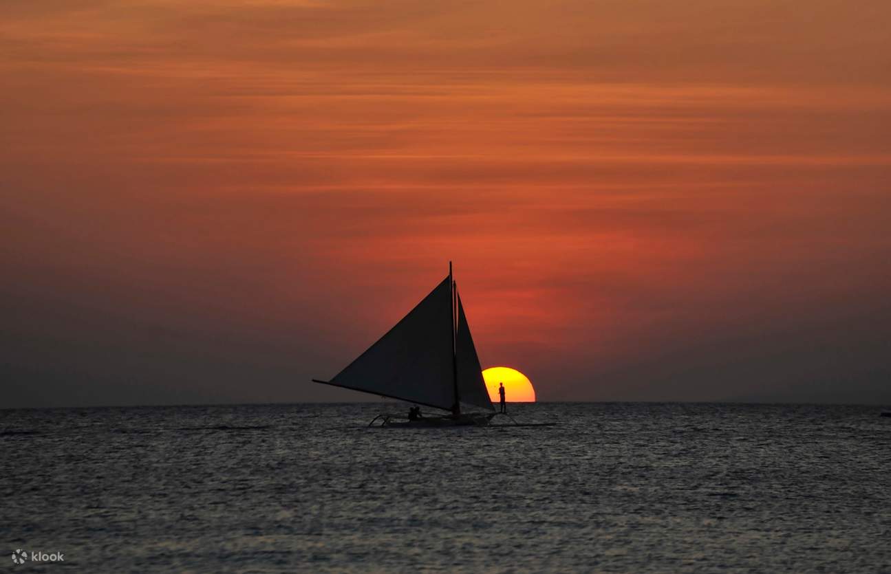日落在長灘島與太陽和 paraw 船