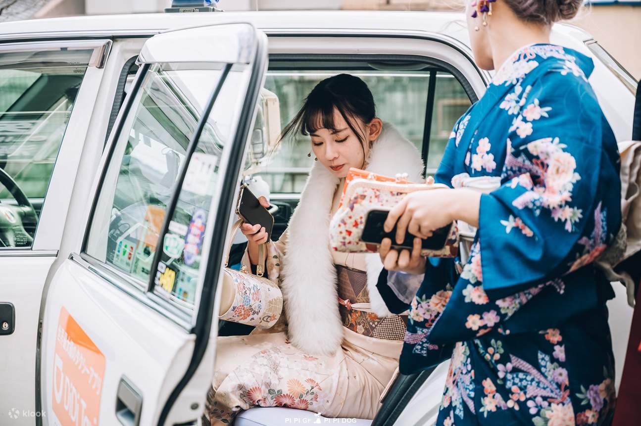 women in kimono getting off from the taxi