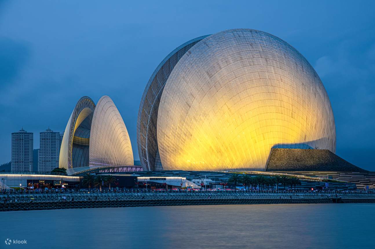 【Zhuhai—Di Tepi Kerang Bulan Matahari】Dengan desain uniknya yang menyerupai dua kerang, memancarkan cahaya lembut di bawah kegelapan malam, membentangkan panorama pemandangan malam tepi laut yang sangat romantis untuk Anda.