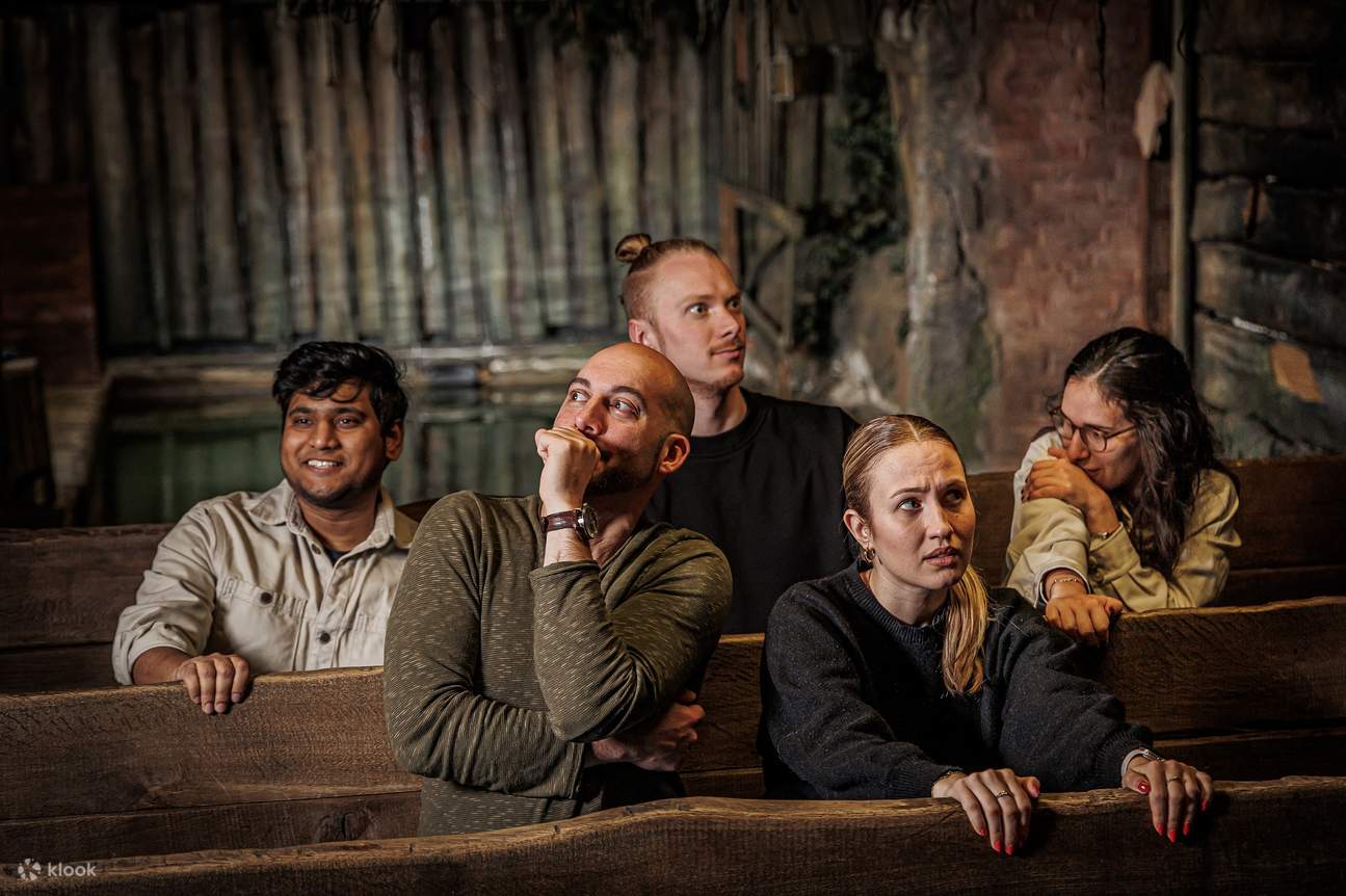 一群遊客坐在地牢裡，看起來很害怕