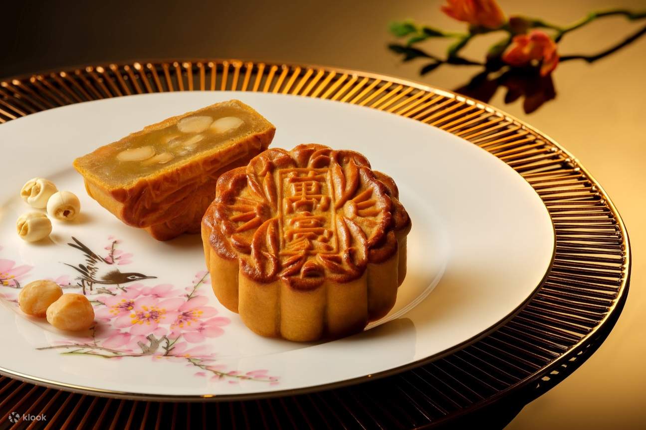 体验经典优雅的迷人风味！我们的白莲蓉月饼口感滑顺，并大方地加入顶级夏威夷豆，在绵密香甜中，交织着令人满足的酥脆口感。每一口都是纯粹的幸福滋味。