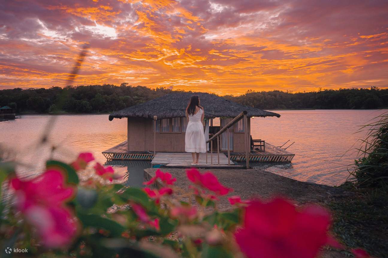 woman in front of the floating house during sunset