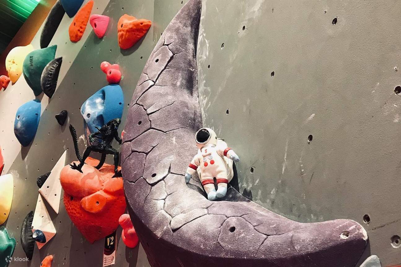 Parete da arrampicata con luna e astronauta nel Gravity Lab di Bangkok