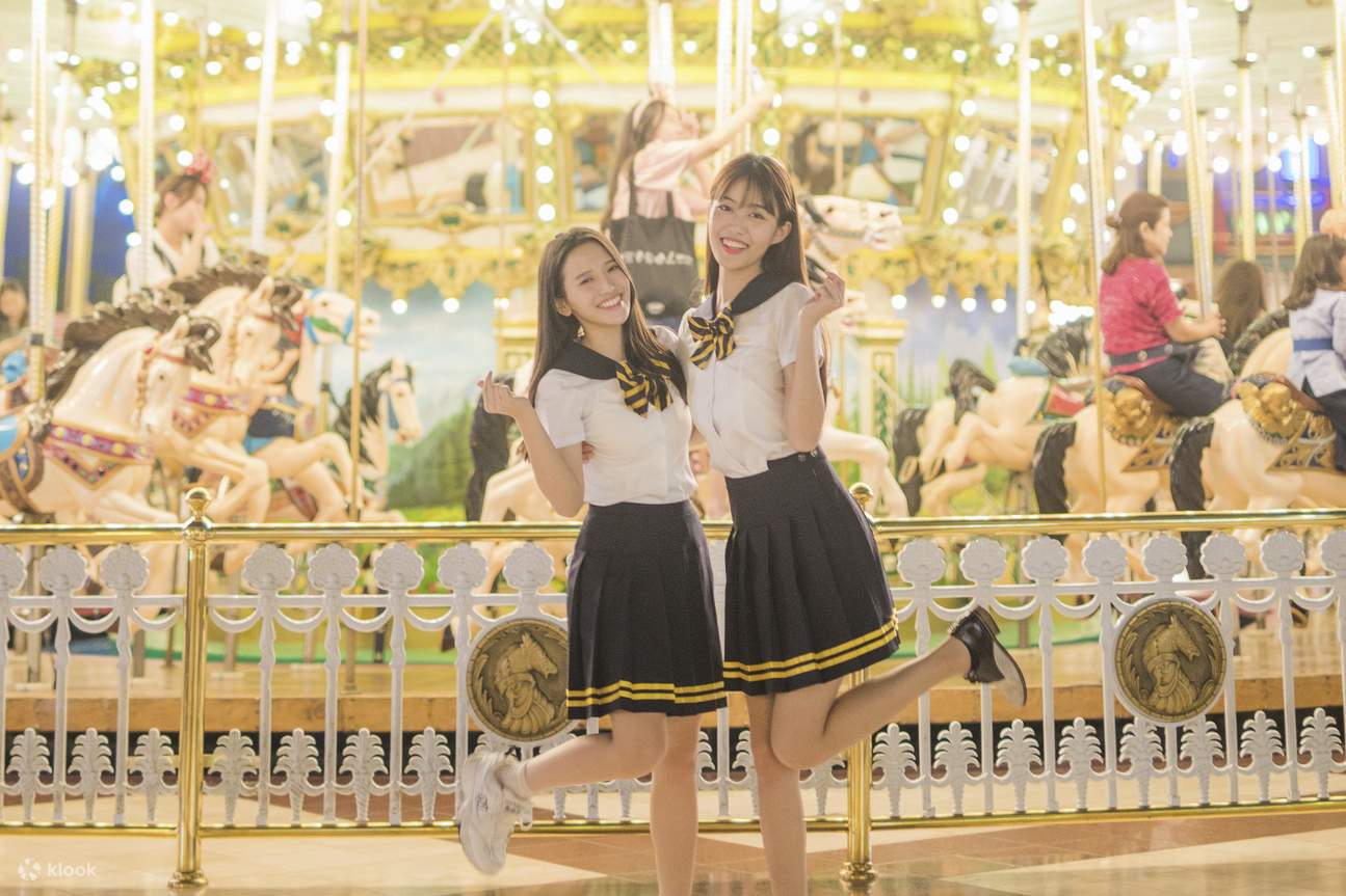 two women wearing korean school uniform at a theme park