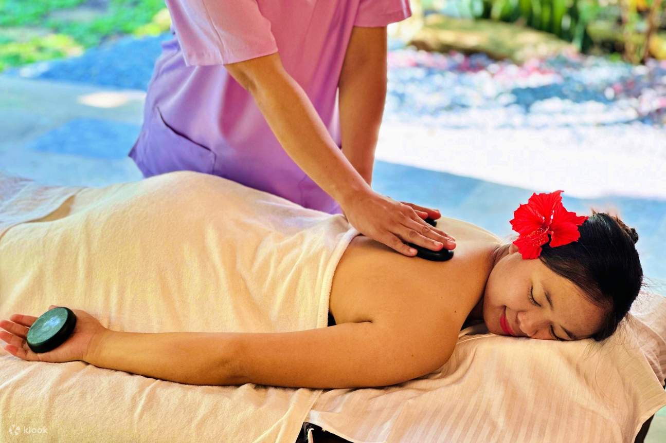 Masseur plaçant des pierres chaudes sur le dos d'une femme