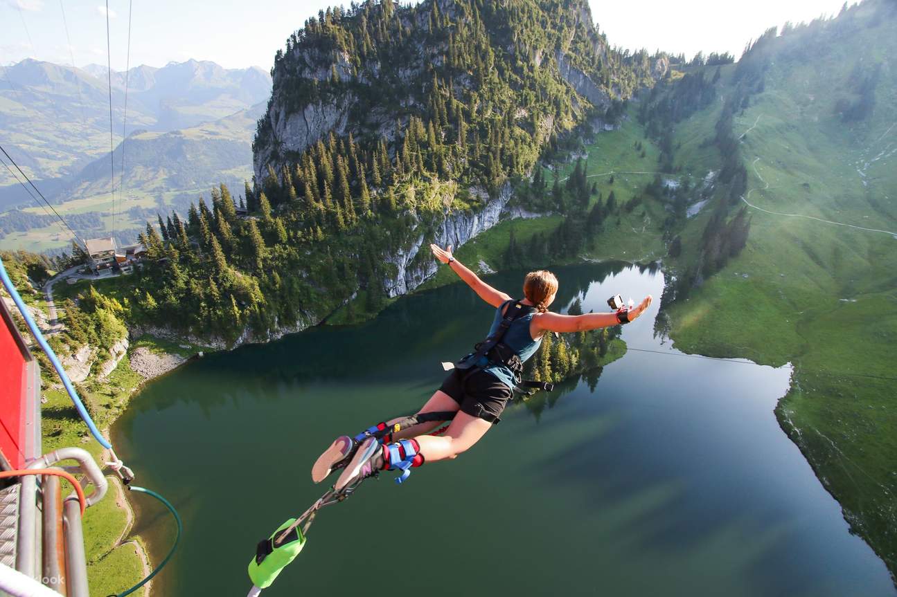 girl opening arms bungee jumping to lake stocksee