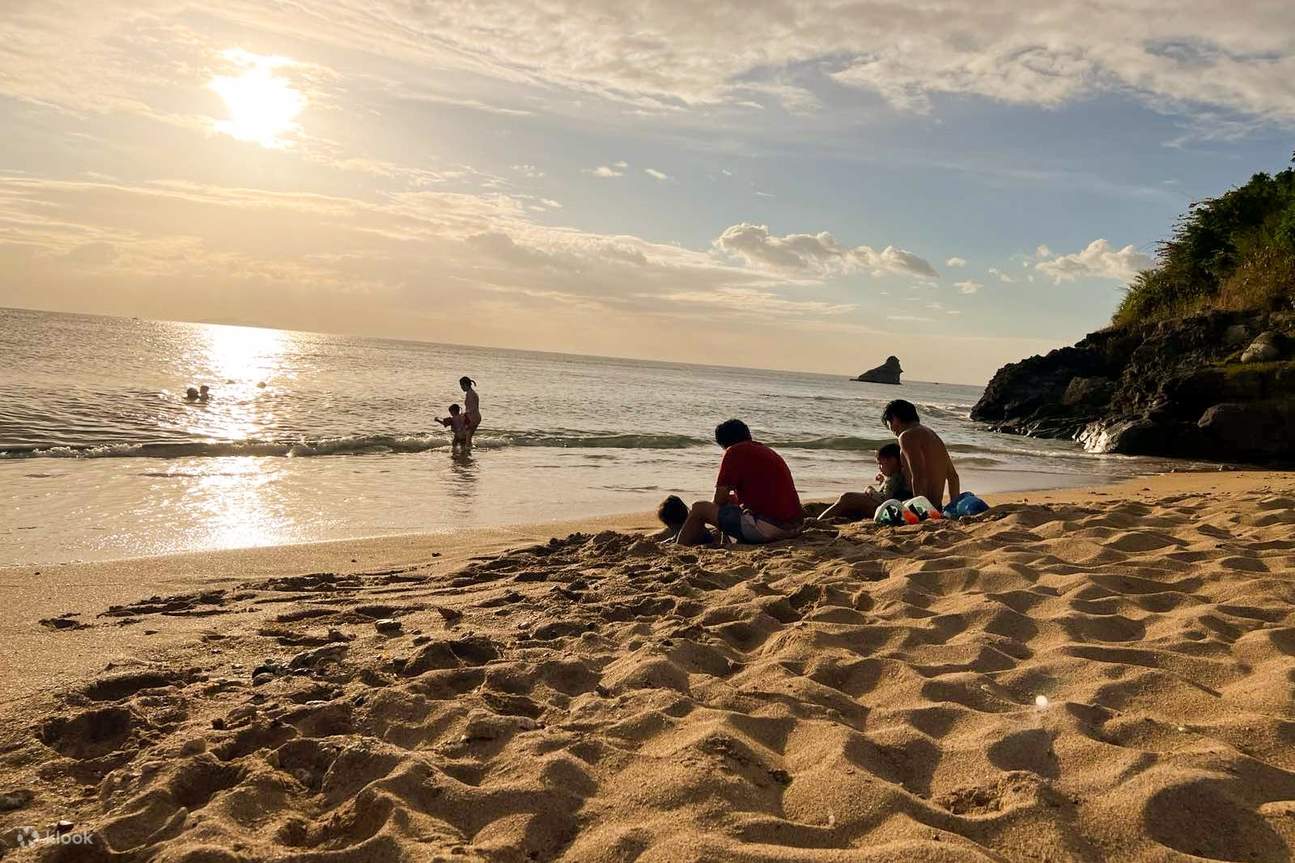 ฉากชายหาดอันเงียบสงบยามพระอาทิตย์ตกดิน ผู้คนมาพักผ่อนและชื่นชมวิวทะเล