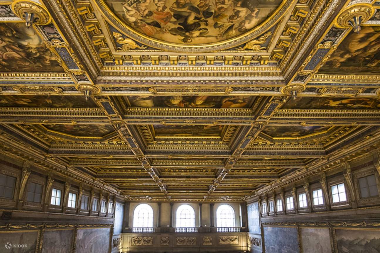 Laissez-vous émerveiller par le plafond de la Salle des Cinq Cents, orné de grandes fresques et de détails complexes.