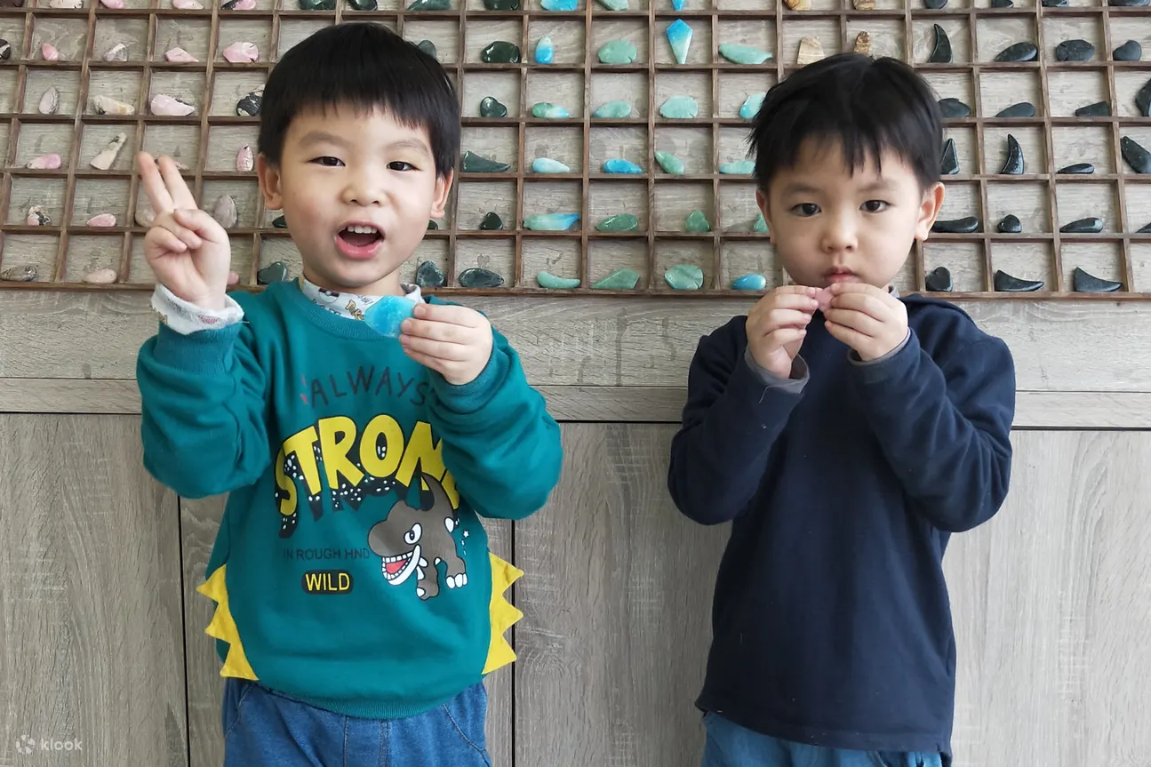 小孩拿着亲手制作的玉石项链