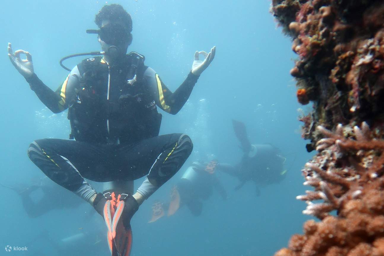 Personne faisant de la plongée sous-marine et posant comme si elle méditait